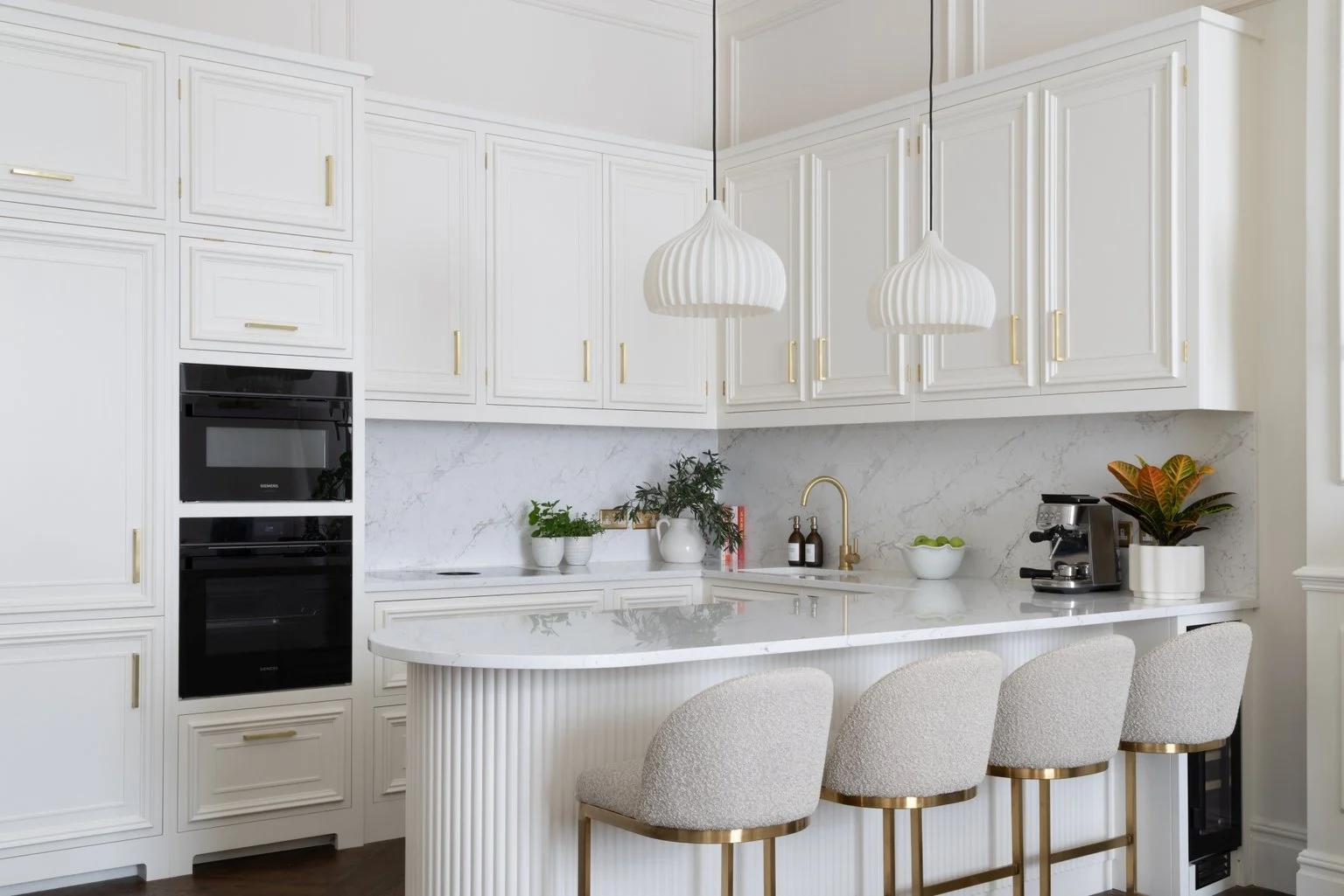 Cashmere panelled kitchen with curved reeded peninsula and brass detailing